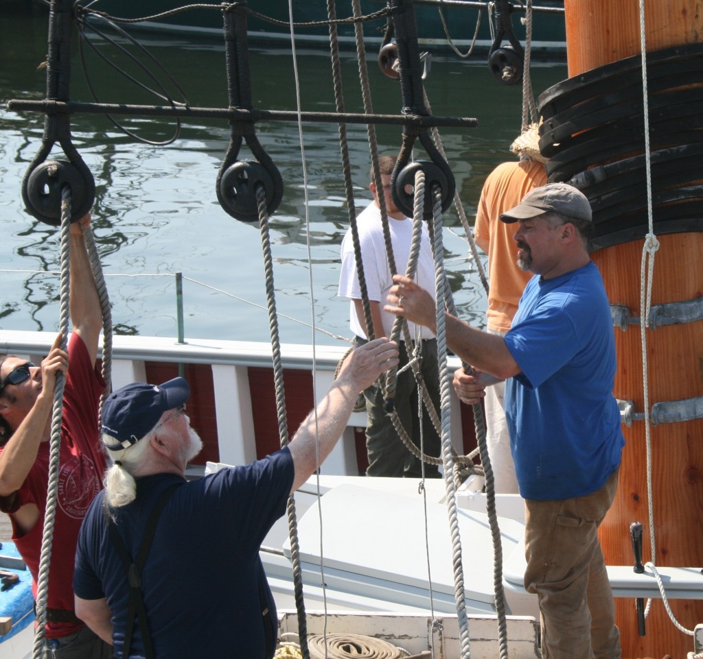 Steve Kirk, Marty Casey (center) and SEMA director Willi Bank Reeving the starboard foremast lanyards last May when the mast were raised.
