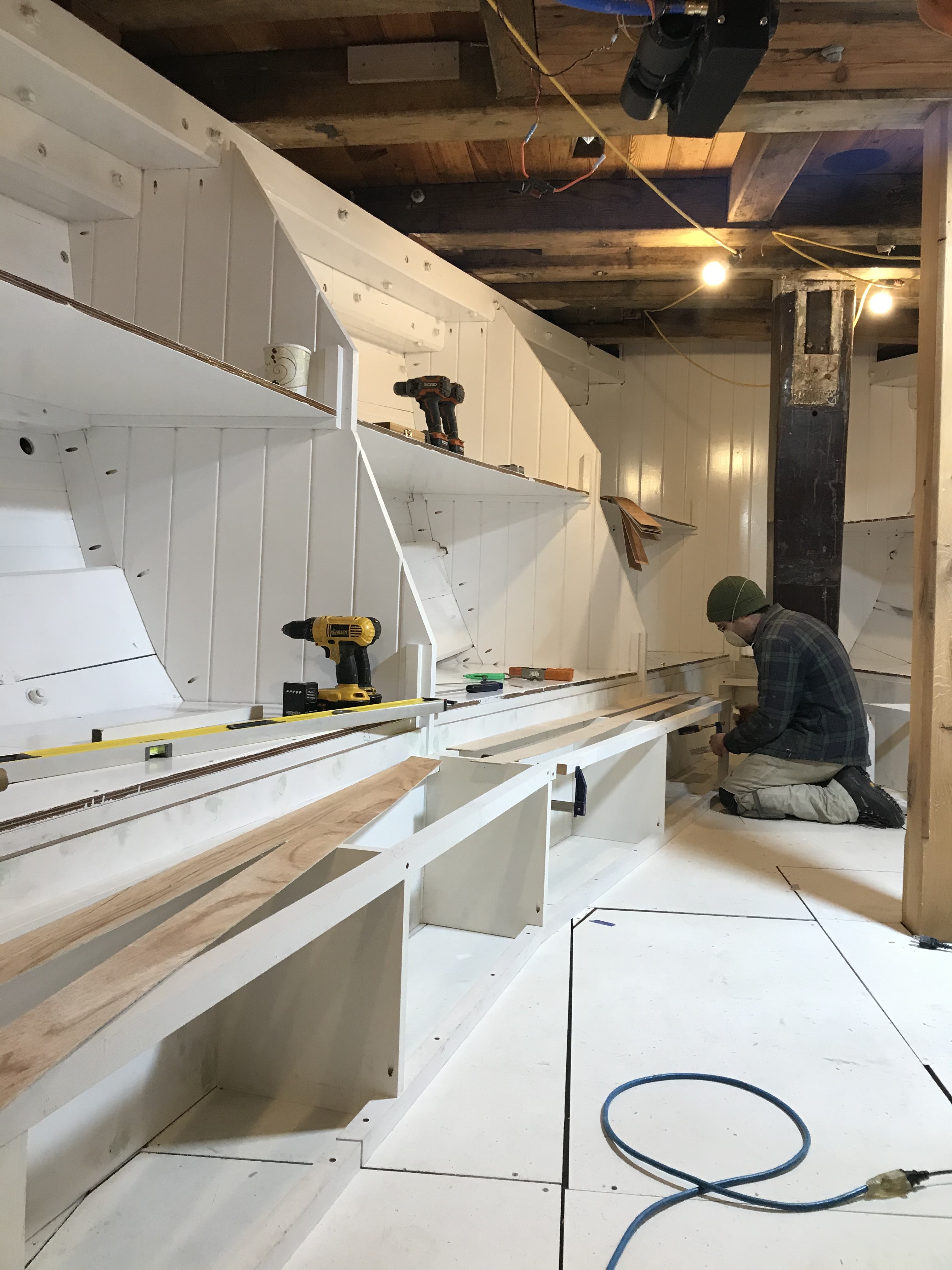 Sam Perkins is carefully fitting the last few vertical partitions for the port side benches.  These benches will serve a dual role in this space.  A large mess table will be built in the center of the cabin and these benches will serve as the seating.  The benches will also serve as storage spaces for the personal belongings of each bunk occupant.