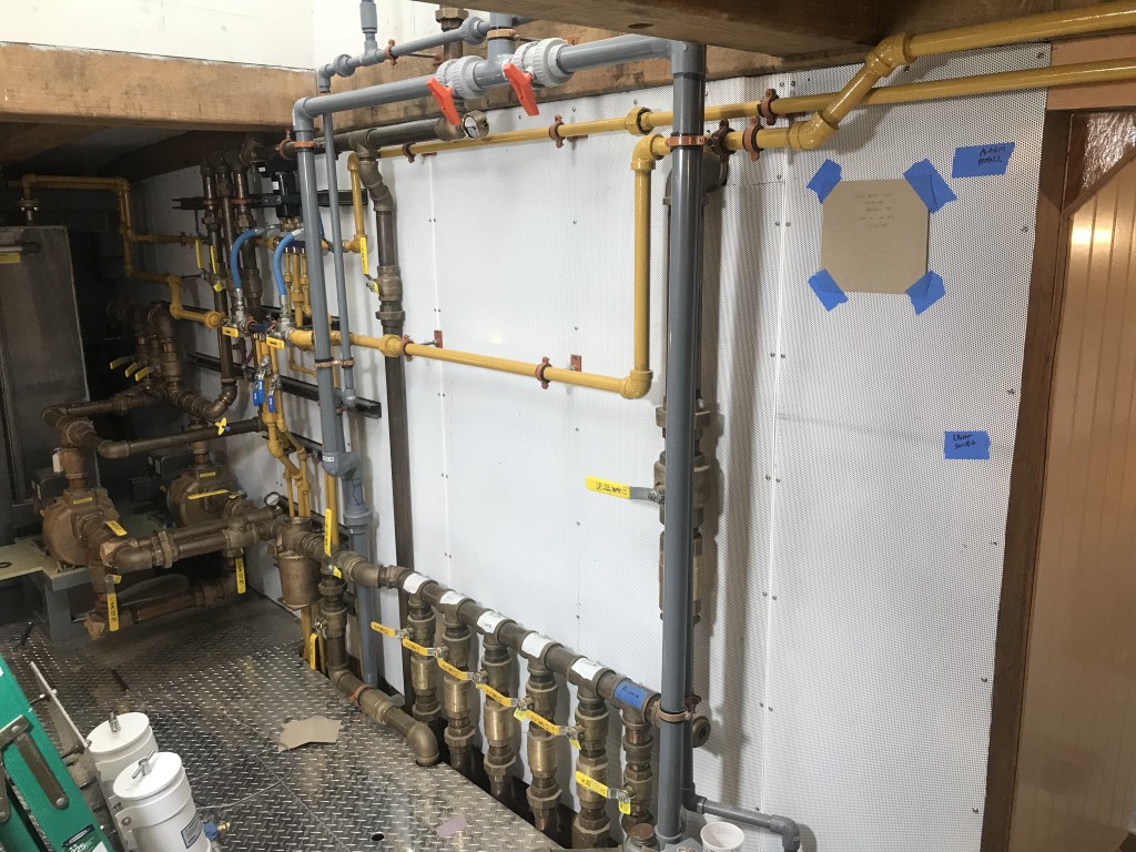 The engine room is chock full of plumbing systems, manifolds, and tanks.  This image shows the majority of this work, nicely arranged and secured to the bulkhead.  Fuel plumbing is colored yellow in accordance with USCG regulations.  Large diameter bronze plumbing is designated to our Fire Suppression and Dewatering systems.  The grey CPVC is USCG certified for fresh water systems.